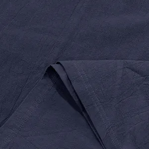 Close-up of navy blue linen fabric showing natural texture and double-stitching detail.