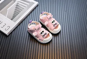 Nahaufnahme der rosa Kleinkindersandalen mit süßem Comic-Bären und weichen weißen Sohlen