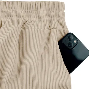 Dettaglio di pantaloncini di velluto a coste beige con elastico in vita e tasca.
