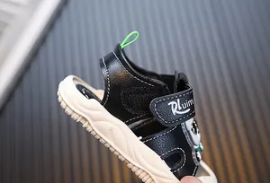 Detailansicht der schwarzen Kleinkindsandalen mit weicher Sohle und Panda-Cartoon-Design