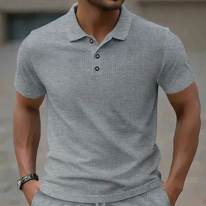 Detailed view of men's grey polo shirt featuring a premium jacquard fabric texture.