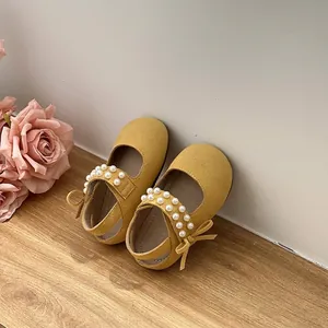 Detailed view of yellow girl's toddler sandals with elegant pearl strap and bow