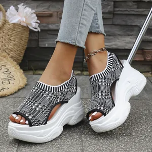Gros plan sur des sandales à plateforme en tricot noir et blanc avec une semelle compensée.