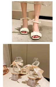 Detailed view of cream square toe sandals with pearl straps and elegant ribbon bows.