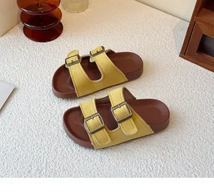 Sandales à double bride en similicuir jaune avec boucles réglables sur fond blanc texturé
