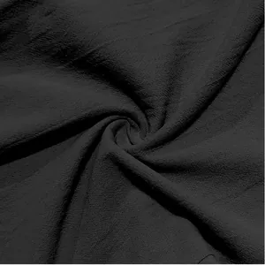 Close-up of black breathable linen fabric texture with natural wrinkled weave