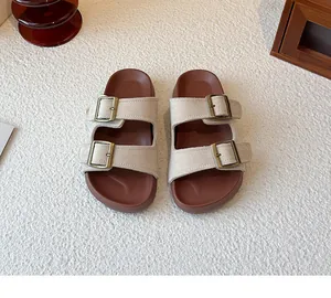 Vue détaillée de sandales en daim beige à deux brides avec boucles en bronze