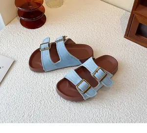 Vue détaillée des sandales en daim bleu clair avec boucles en bronze réglables.