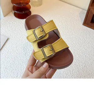 Vue détaillée des claquettes jaunes pour femmes à double boucle avec finition bronze.