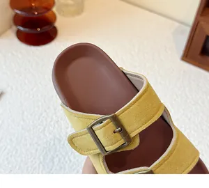 Vue macro détaillée des sandales en daim jaune avec boucles en métal bronze vintage
