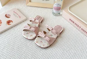 Elegantes sandalias rosas con un lazo y suela de flores para niñas pequeñas