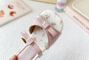 Detalle de las sandalias rosas para niña con estampado floral y bonitos lazos
