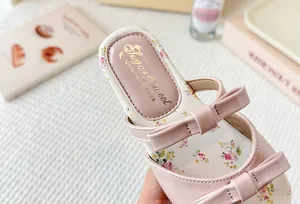 Detalle de sandalias rosas para niñas con lazos decorativos y plantilla floral