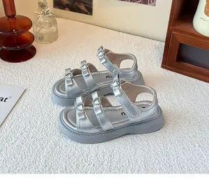 Vista de detalle de sandalias de princesa plateadas para niñas con hebillas de corazón.