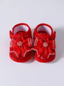 Detail view of red baby princess shoes with sequin bow and rhinestones