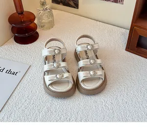 Detalle de sandalias blancas para niña con tres hebillas de corazón y purpurina