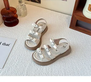 Detalle de sandalias blancas para niñas con hebillas de diamantes de corazón y lazos.