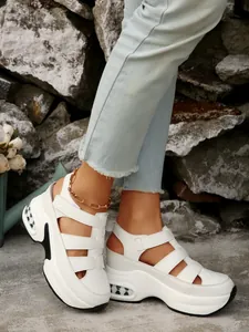 Primer plano de sandalias de cuña blancas con cierre de velcro usadas por modelo