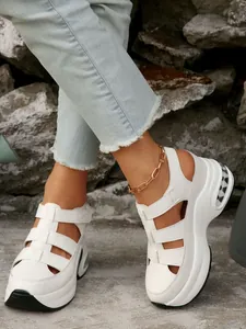 Vista de cerca de sandalias blancas con plataforma, cuña y velcro en una modelo
