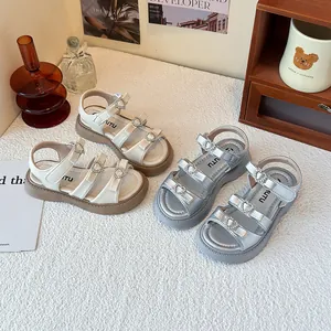 Elegantes sandalias de verano para niñas con hebillas de corazón y lazos en blanco y plata.