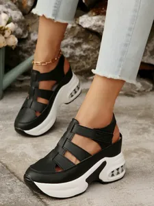 Vista detallada de sandalias de plataforma negras para mujer con cierre de velcro.