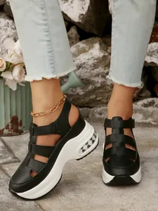 Elegantes sandalias negras con plataforma y cuña, punta cerrada y correas de velcro.