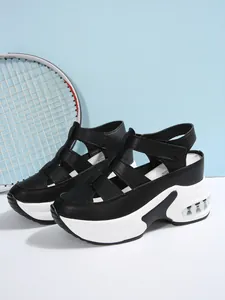 Detalle de sandalias negras de cuña con velcro y suela con cámara de aire cómoda