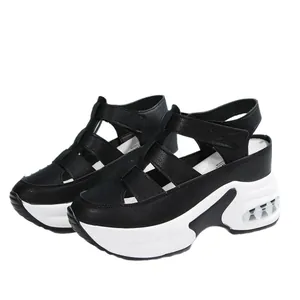 Sandalias de cuña negras para mujer con suelas blancas gruesas y cierres de velcro.