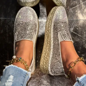 Gros plan sur des mocassins à plateforme scintillants avec paillettes d'argent et strass