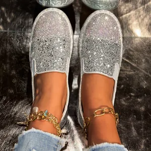 Gros plan détaillé de mocassins argentés pour femmes avec strass étincelants et paillettes