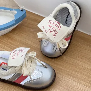 Nahaufnahme silberner atmungsaktiver Baby-Sneaker mit weicher brauner Anti-Rutsch-Sohle