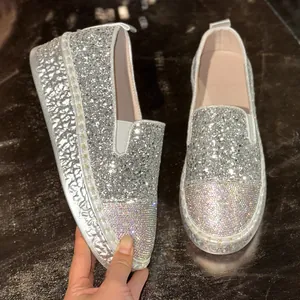 Vue détaillée des strass étincelants et de la texture des paillettes argentées des mocassins.