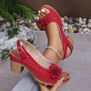 Detailed view of red chunky heel sandals with floral accents and laser-cut design