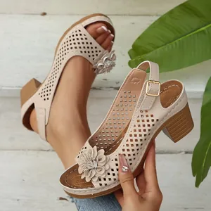 Detail of beige block heel sandal featuring laser-cut pattern and 3D floral accent.