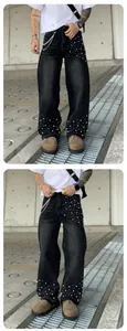 Detail view of men's loose black straight jeans featuring white pearl bead decorations.