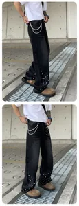 Detail of men's loose straight black denim jeans with pearl bead embellishments