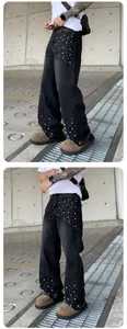Detail of men's loose straight jeans with decorative white pearls on black denim