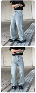 Detail view of men's loose straight jeans featuring pearl beading and frayed hems.