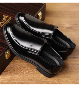 Detailed view of polished black men's slip-on leather shoes on wooden background