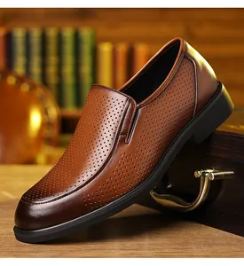 Close-up detail of the breathable perforated texture on brown leather men's dress shoes