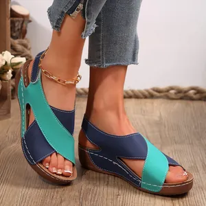 Primer plano de sandalias con cuña para mujer con correas cruzadas en azul y turquesa.