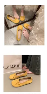 Dettaglio di ballerine in camoscio giallo con un grazioso fiocco e punta arrotondata