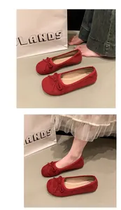 Vista dettagliata di ballerine in camoscio rosso con fiocco su sfondo lifestyle