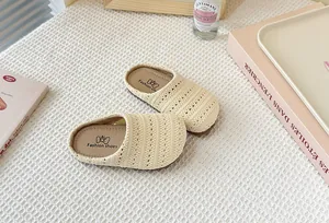 Primer plano de pantuflas tejidas transpirables en color crema para niños para verano