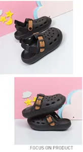 Vue détaillée de sabots noirs pour enfants avec boucle décorative pour la plage