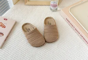 Detalle de mules infantiles de tejido calado transpirable en color beige crema.