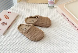 Primer plano de zuecos infantiles beige de tejido transpirable sobre fondo blanco