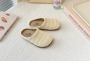Detalle de los zuecos de malla tejida transpirable para niños en beige con suela.