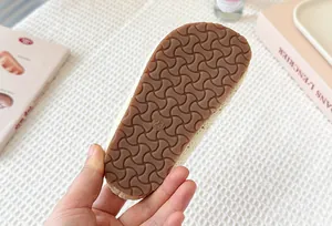 Detalle de la suela de goma antideslizante marrón en zuecos tejidos transpirables para niños
