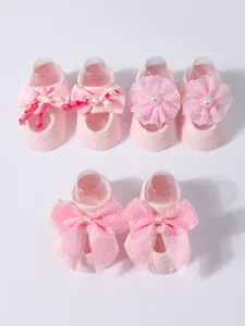 Set of three pink baby socks featuring varied floral and bow decorations